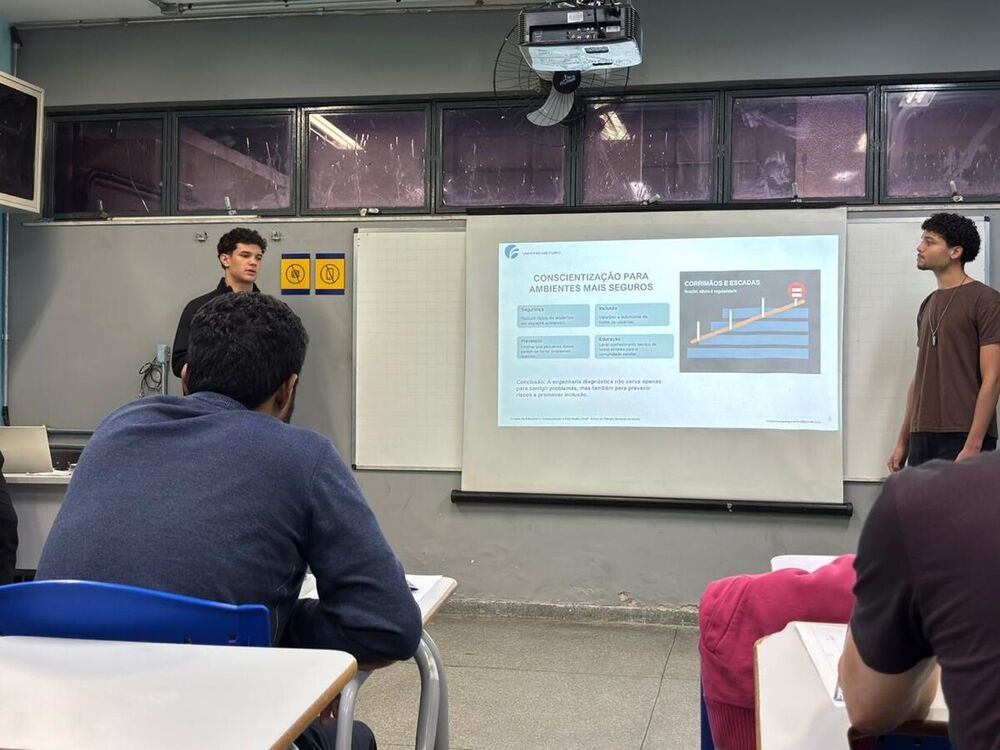 Integrantes da equipe apresentam um slide sobre ambientes mais seguros